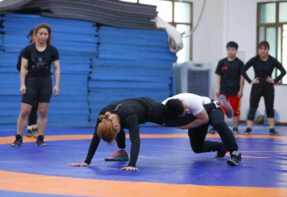 HLV Trần Văn Sơn hướng dẫn kỹ thuật cho vận động viên đội tuyển vật nữ. (Ảnh: Hoàng Hiếu/TTXVN)