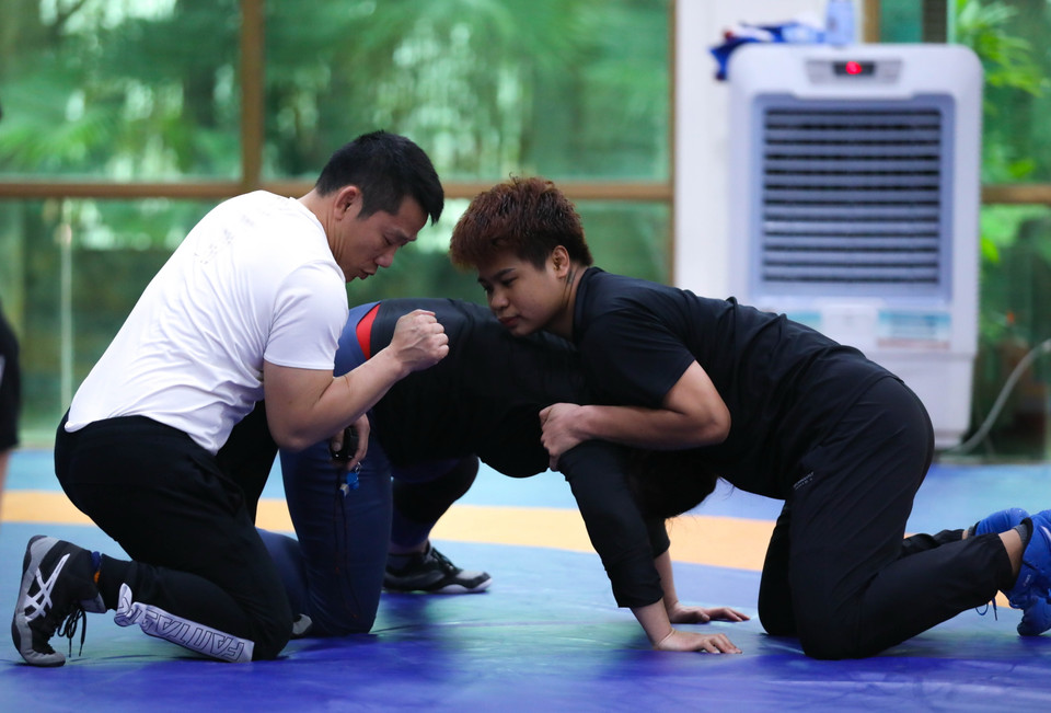 HLV Trần Văn Sơn hướng dẫn kỹ thuật cho vận động viên Võ Thị Kim Chi (huy chương Vàng giải Vật vô địch Đông Nam Á hạng 68kg). (Ảnh: Hoàng Hiếu/TTXVN)