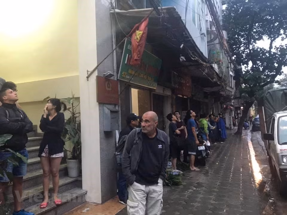 Các du khách nước ngoài được sơ tán qua phía bên kia đường. Khi đám cháy mới xảy ra, vẫn còn một số người mắc kẹt trên tầng cao. (Ảnh: CTV/Vietnam+)