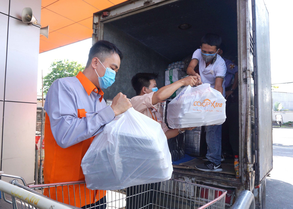 Các suất ăn nóng hổi được vận chuyển nhanh đến với người dân trong khu cách ly. (Ảnh: Thanh Vũ-Tuyết Thư/TTXVN)