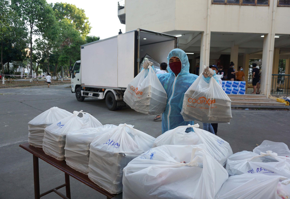 Những suất ăn do Sài Gòn Co.op thực hiện được các nhân viên trong khu cách ly khu A Ký túc xá Đại học Quốc gia Thành phố Hồ Chí Minh tiếp nhận trước khi trao cho những người dân trong khu cách ly. (Ảnh: Thanh Vũ-Tuyết Thư/TTXVN)