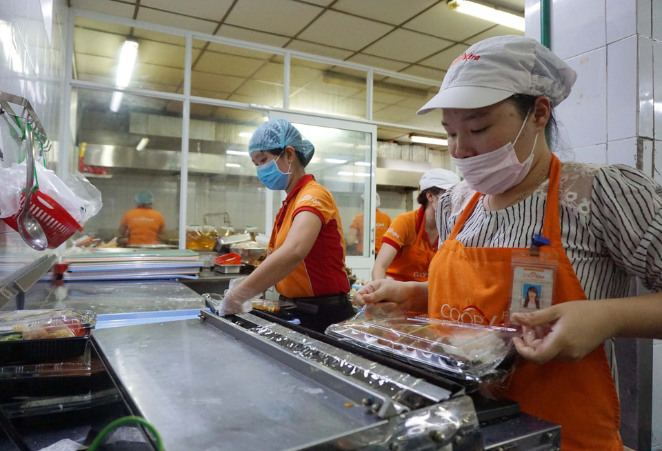 Mỗi suất ăn được nhân viên Sài Gòn Co.op cho vào hộp và đóng gói cẩn thận trước khi chuyển đến phục vụ người dân trong khu cách ly. (Ảnh: Thanh Vũ-Tuyết Thư/TTXVN)