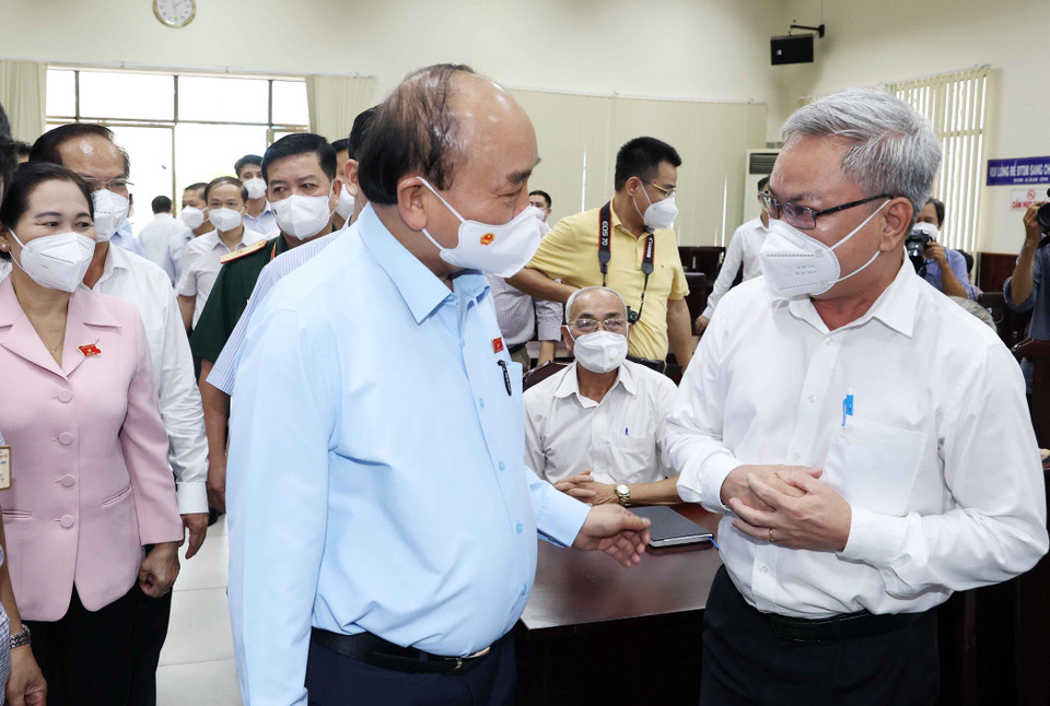 Chủ tịch nước Nguyễn Xuân Phúc trò chuyện với cử tri huyện Hóc Môn trước buổi tiếp xúc cử tri. (Ảnh: Thống Nhất/TTXVN)