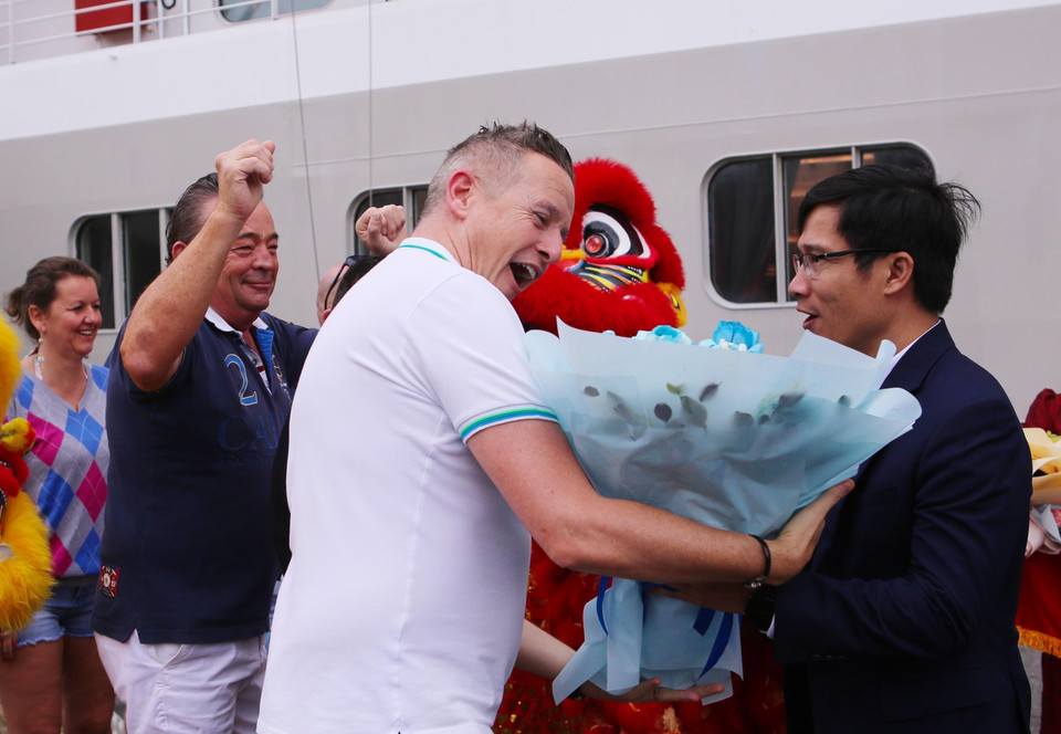 Phó Giám đốc Sở Du lịch Đà Nẵng Tán Văn Vương chúc mừng các du khách đầu tiên đến Đà Nẵng bằng đường biển. (Ảnh: Trần Lê Lâm/TTXVN)