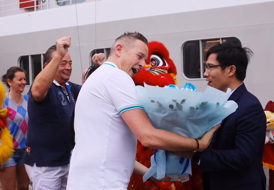 Phó Giám đốc Sở Du lịch Đà Nẵng Tán Văn Vương chúc mừng các du khách đầu tiên đến Đà Nẵng bằng đường biển. (Ảnh: Trần Lê Lâm/TTXVN)