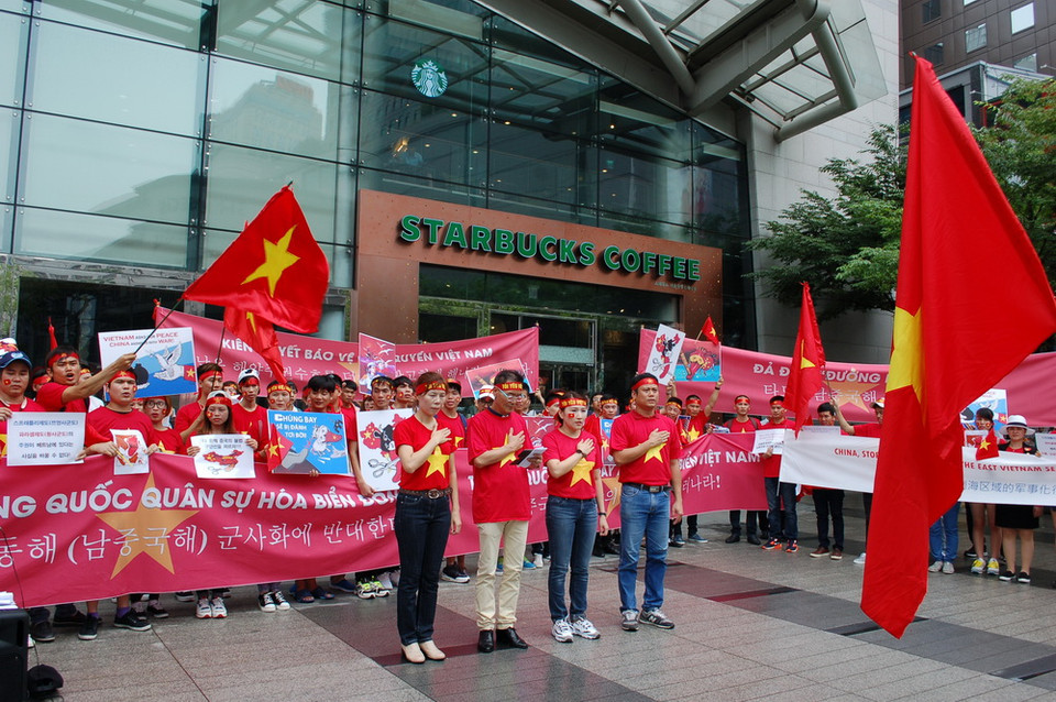 Đoàn người biểu tình làm lễ chào cờ, hát Quốc ca. (Ảnh: Vũ Toàn-Phạm Duy/Vietnam+)