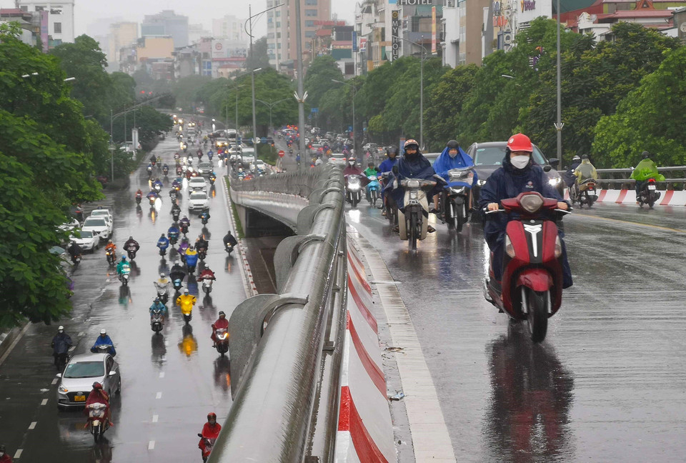 Người dân lưu thông trên cầu vượt Trần Khát Chân trong cơn mưa sáng 11/8. (Ảnh: Thanh Tùng/TTXVN)