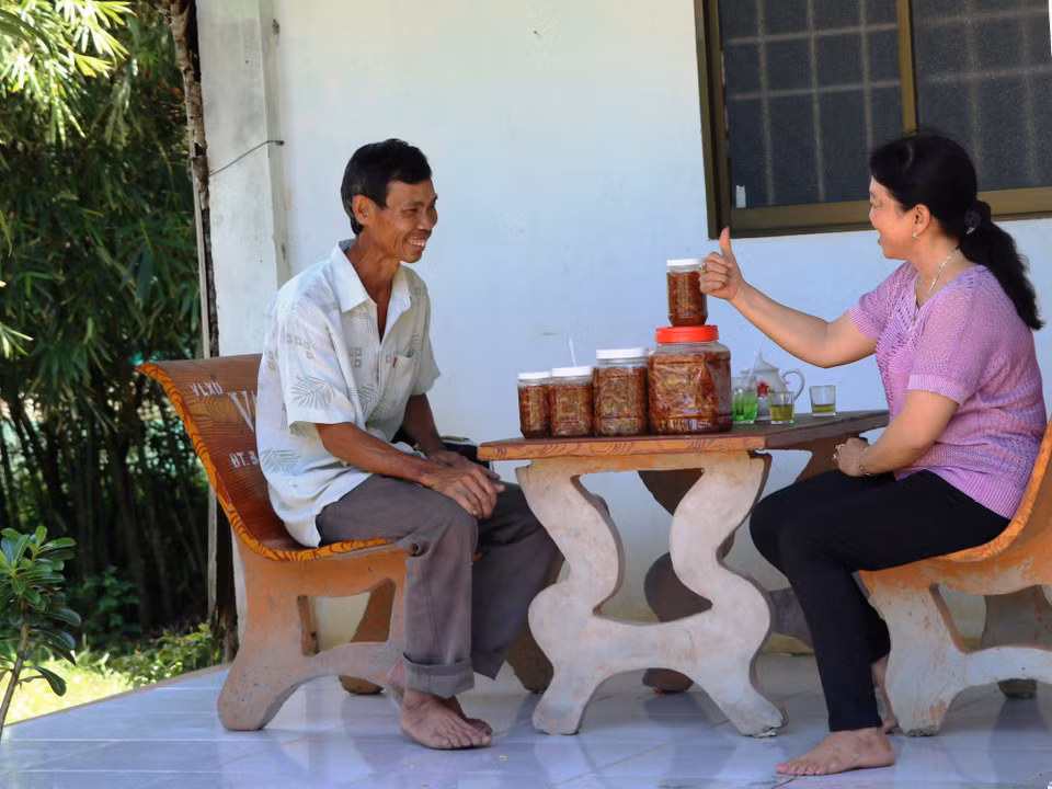 Anh Lê Văn Miền hào hứng và tâm đắc khi lắng nghe vợ mình thuyết trình về kế hoạch làm mắm tôm chua để tăng thêm thu nhập cho gia đình. (Ảnh: PV/Vietnam+)