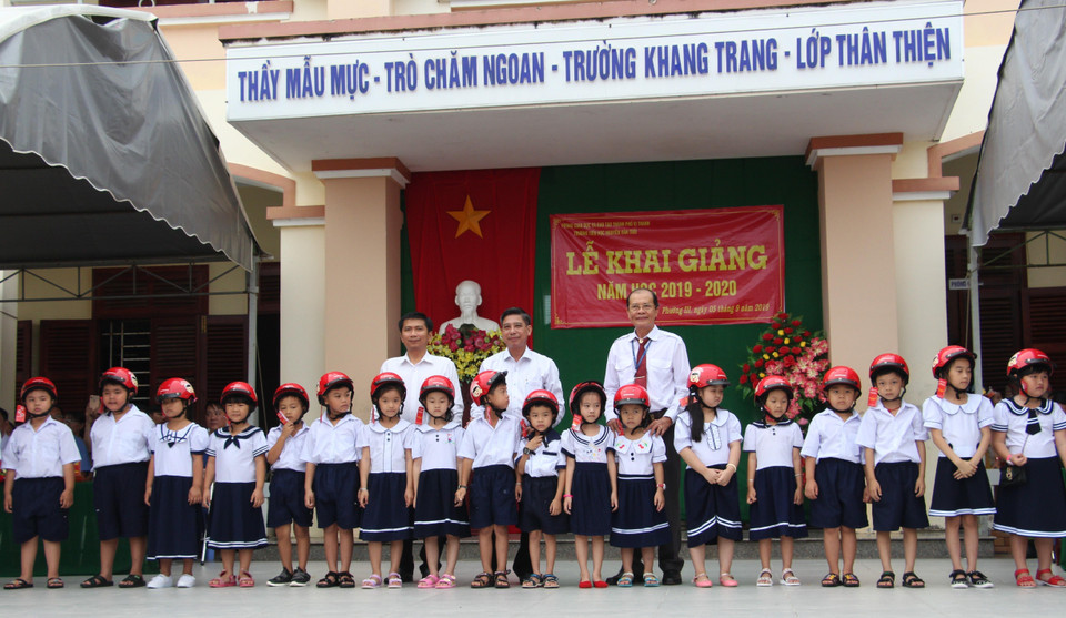 Trao tặng mũ bảo hiểm cho học sinh trường Tiểu học Nguyễn Văn Trỗi, thành phố Vị Thanh (Hậu Giang) nhân dịp năm học mới. (Ảnh: Hồng Thái/TTXVN)