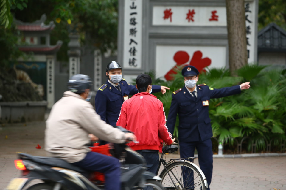 Lực lượng chức năng nhắc nhở người dân thực hiện nghiêm theo quy định. (Ảnh: Minh Quyết/TTXVN)