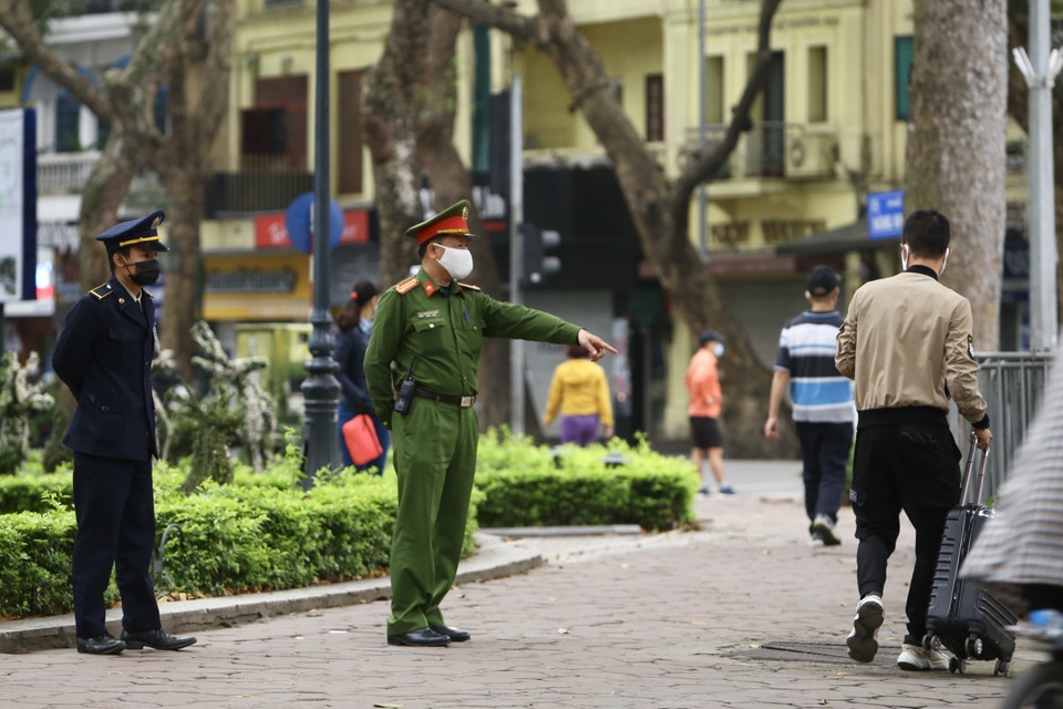 Lực lượng chức năng nhắc nhở người dân thực hiện nghiêm theo quy định. (Ảnh: Minh Quyết/TTXVN)