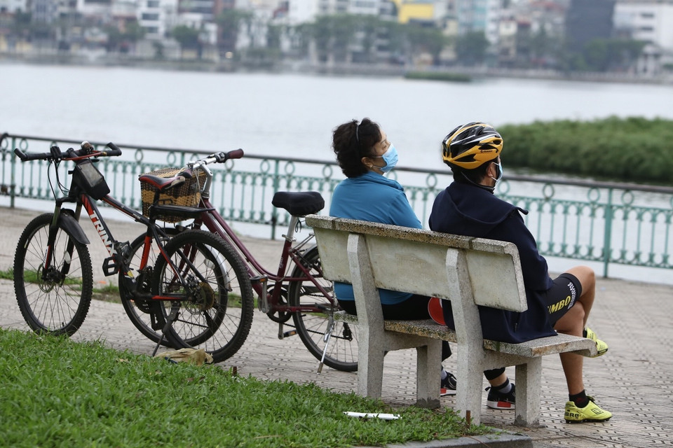 Nhiều người vẫn tập thể dục, ngồi sát nhau. (Ảnh: Minh Quyết/TTXVN)