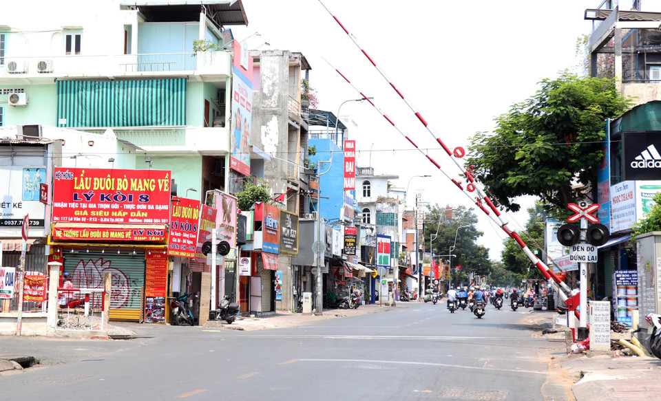 Rào chắn đường xe lửa tại đường Lê Văn Sỹ hôm nay hầu như không phải hạ xuống khi các chuyến tàu lửa Bắc-Nam đã hạn chế hoạt động. (Ảnh: Xuân Khu/TTXVN)