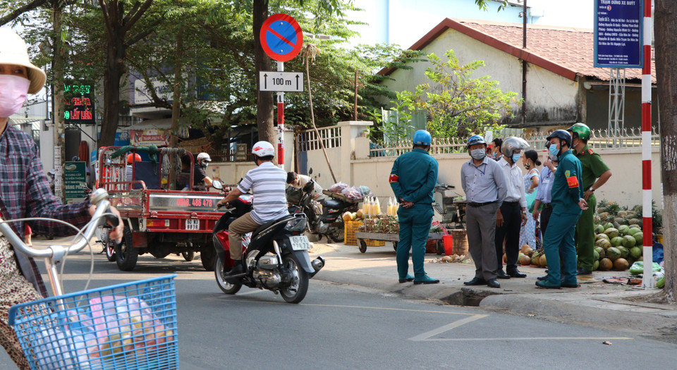Lực lượng chức năng hướng dẫn, nhắc nhở người dân ý thức trong việc không tụ tập đông người tại nơi công cộng tại Đồng Nai. (Ảnh: Sỹ Tuyên/TTXVN)