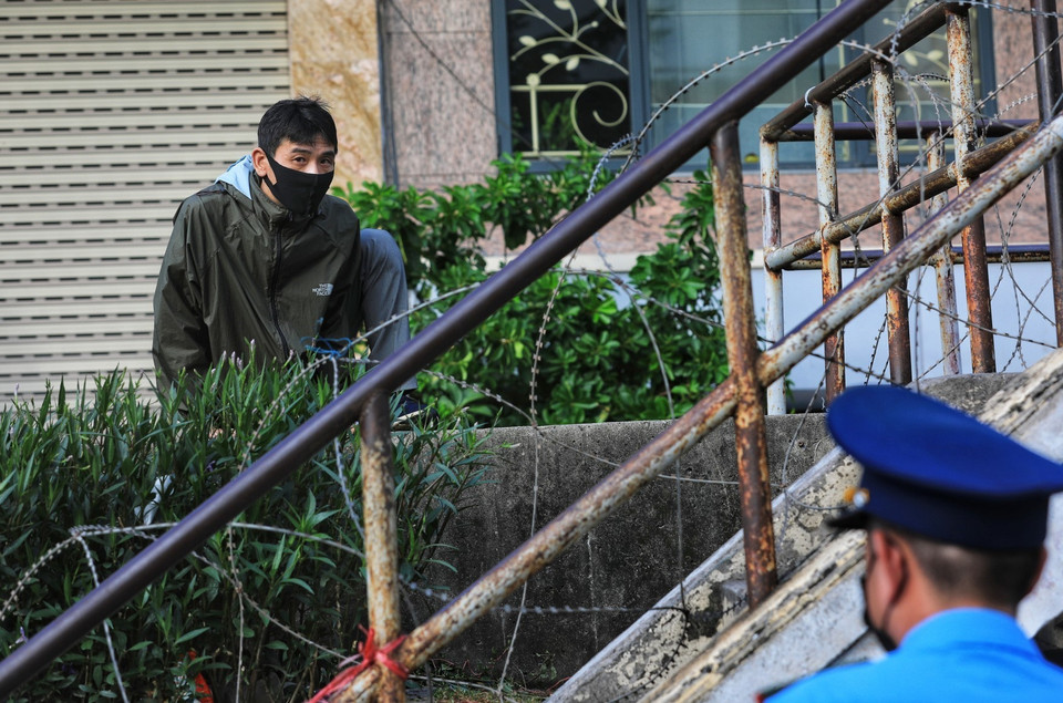 Nhiều người dân ở trong khu cách ly lợi dụng những chỗ không có chốt kiểm soát vẫn cố tình trèo tường qua hàng rào. (Ảnh: Thành Đạt/TTXVN)