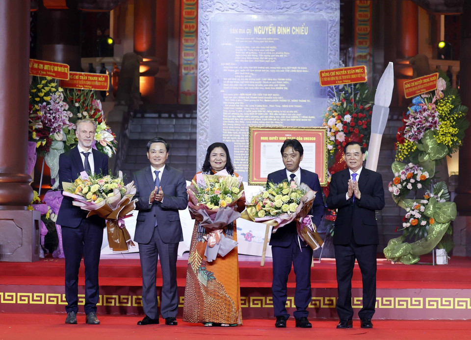Lãnh đạo tỉnh Bến Tre tặng hoa cho ông Christian Manhart, Trưởng đại diện UNESCO tại Việt Nam. (Ảnh: Thống Nhất/TTXVN)
