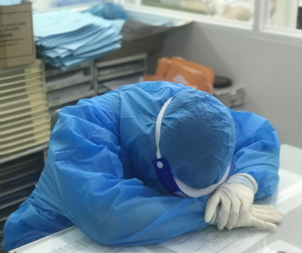 Một y, bác sỹ của Bệnh viện Dã chiến số 1 điều trị COVID-19 Khánh Hòa nằm tạm nghỉ lấy sức trên bàn làm việc. (Ảnh: TTXVN phát)