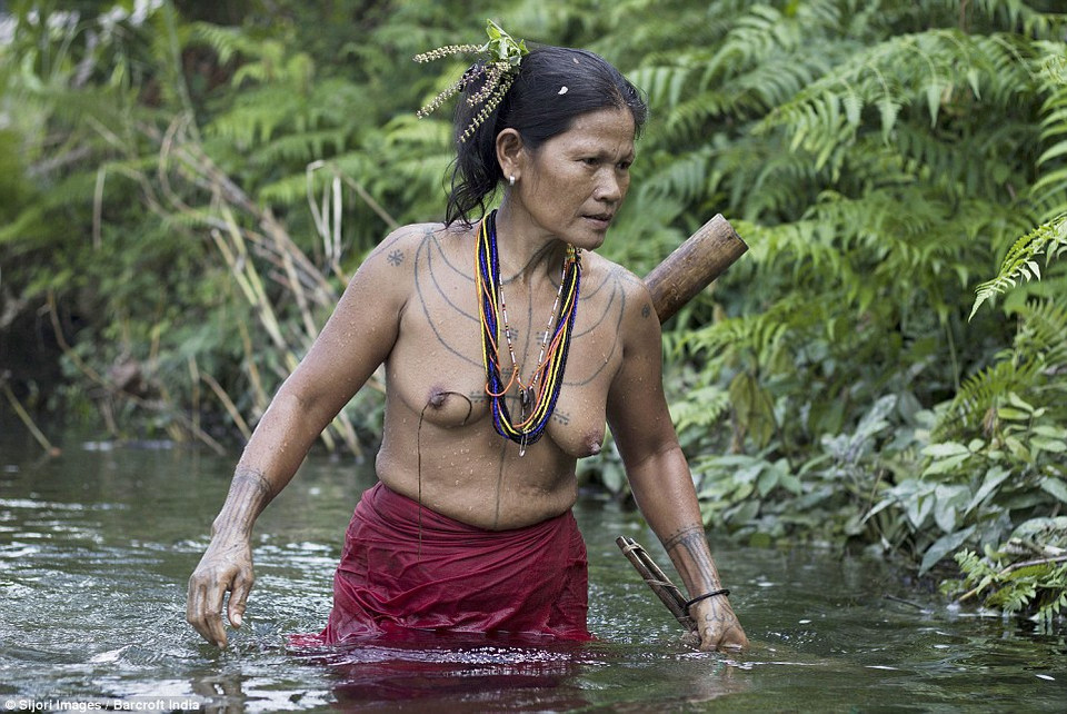 Một phụ nữ bộ tộc đang bắt cá dưới suối. (Nguồn: DM)