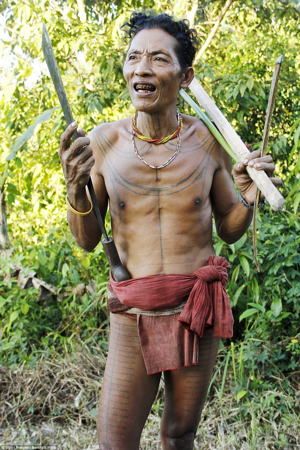Một thợ săn người Mentawai đang cầm dao và một ít thân cây tre. (Nguồn: DM)