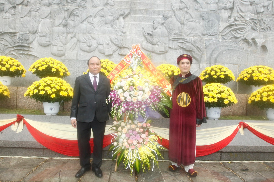 Thủ tướng Nguyễn Xuân Phúc và đồng chí Bùi Minh Châu, Chủ tịch UBND tỉnh Phú Thọ dâng hoa tại bức phù điêu có hình tượng Chủ tịch Hồ Chí Minh nói chuyện với Đại đoàn quân Tiên phong năm 1954. (Ảnh: Lâm Khánh/TTXVN)