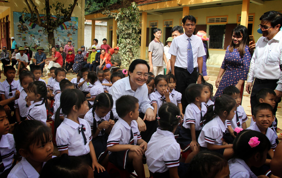 Bộ trưởng Phùng Xuân Nhạ với học sinh Trường tiểu học Tân Hóa, huyện Minh Hóa, tỉnh Quảng Bình. (Ảnh: Văn Tý/TTXVN) 