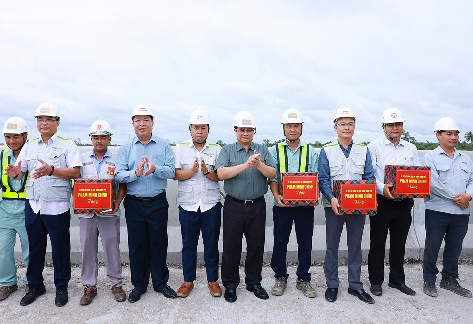 Thủ tướng Phạm Minh Chính tặng quà công nhân thi công cao tốc Cần Thơ-Cà Mau đoạn qua huyện Phụng Hiệp, tỉnh Hậu Giang. (Ảnh: Dương Giang/TTXVN)