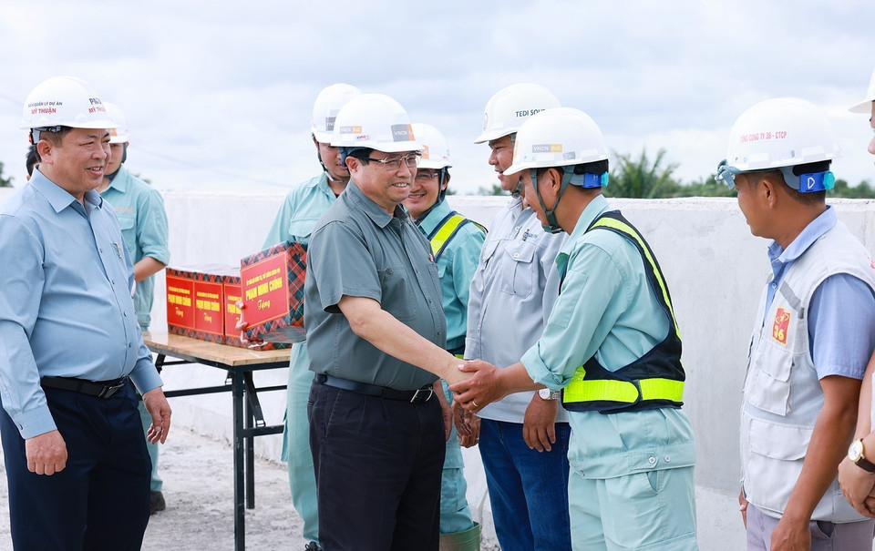 Thủ tướng Phạm Minh Chính với công nhân thi công cao tốc Cần Thơ-Cà Mau đoạn qua huyện Phụng Hiệp, tỉnh Hậu Giang. (Ảnh: Dương Giang/TTXVN)