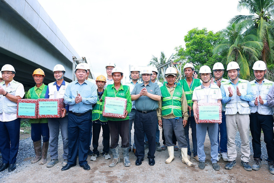 Thủ tướng Phạm Minh Chính tặng quà công nhân thi công cao tốc đoạn Cần Thơ-Hậu Giang. (Ảnh: Dương Giang/TTXVN)