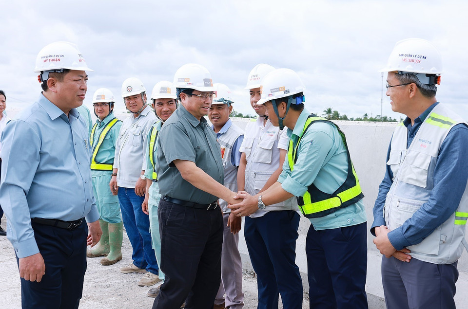 Thủ tướng Phạm Minh Chính với công nhân thi công cao tốc Cần Thơ-Cà Mau đoạn qua huyện Phụng Hiệp, tỉnh Hậu Giang. (Ảnh: Dương Giang/TTXVN)