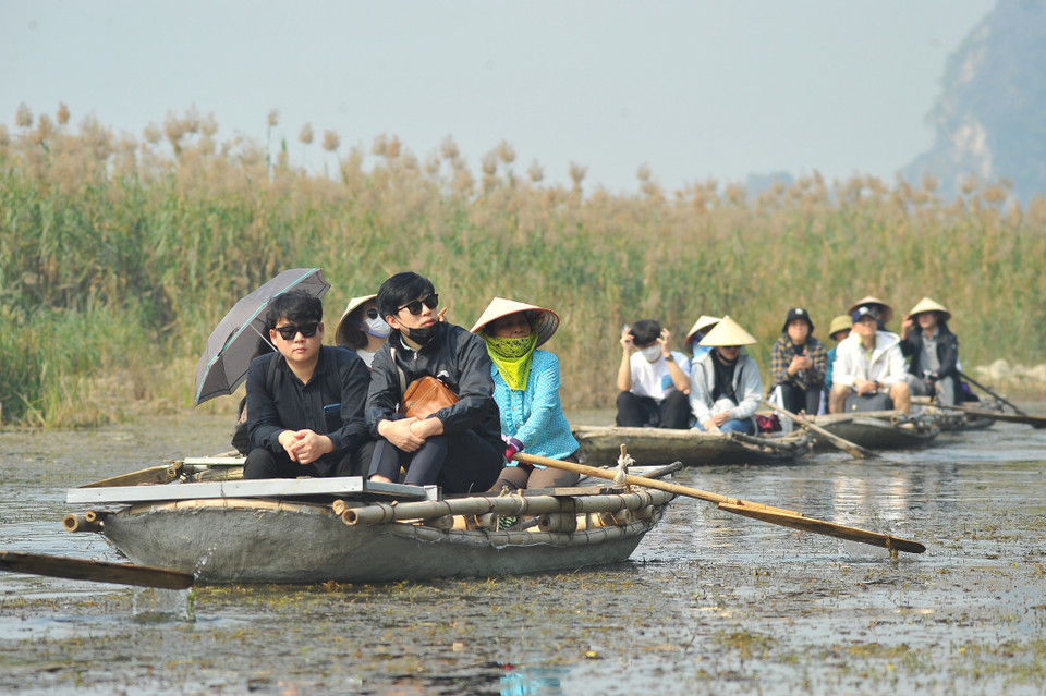 Du khách trong và ngoài nước tham quan khu bảo tồn thiên nhiên đất ngập nước Vân Long bằng thuyền. (Ảnh: Minh Đức/TTXVN)