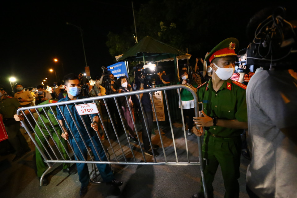 Lực lượng chức năng dỡ bỏ hàng rào cách ly thôn Hạ Lôi. (Ảnh: Minh Quyết/TTXVN)