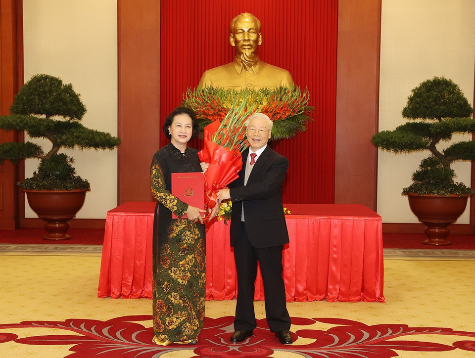 Tổng Bí thư Nguyễn Phú Trọng trao Quyết định và tặng hoa đồng chí Nguyễn Thị Kim Ngân, nguyên Ủy viên Bộ Chính trị, nguyên Bí thư Đảng đoàn Quốc hội, nguyên Chủ tịch Quốc hội. (Ảnh: Trí Dũng/TTXVN)