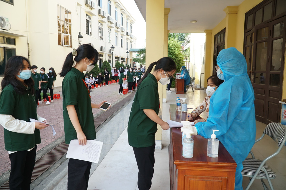 Học sinh tuân thủ nguyên tắc 5K khi đến tiêm vaccine tại trường THPT Chuyên Phan Bội Châu, thành phố Vinh. (Ảnh: Bích Huệ/TTXVN)