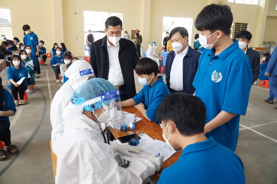 Lãnh đạo Sở Giáo dục và Đào tạo thăm hỏi, động viên học sinh tiêm vaccine tại điểm tiêm trường THPT Chuyên Phan Bội Châu, thành phố Vinh. (Ảnh: Bích Huệ/TTXVN)