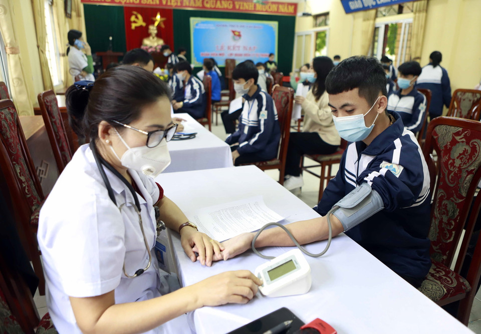 Nhân viên y tế kiểm tra sức khỏe cho học sinh trước khi tiêm, tại Trường THPT Tam Đảo 1, huyện Tam Đảo. (Ảnh: Hoàng Hùng/TTXVN)