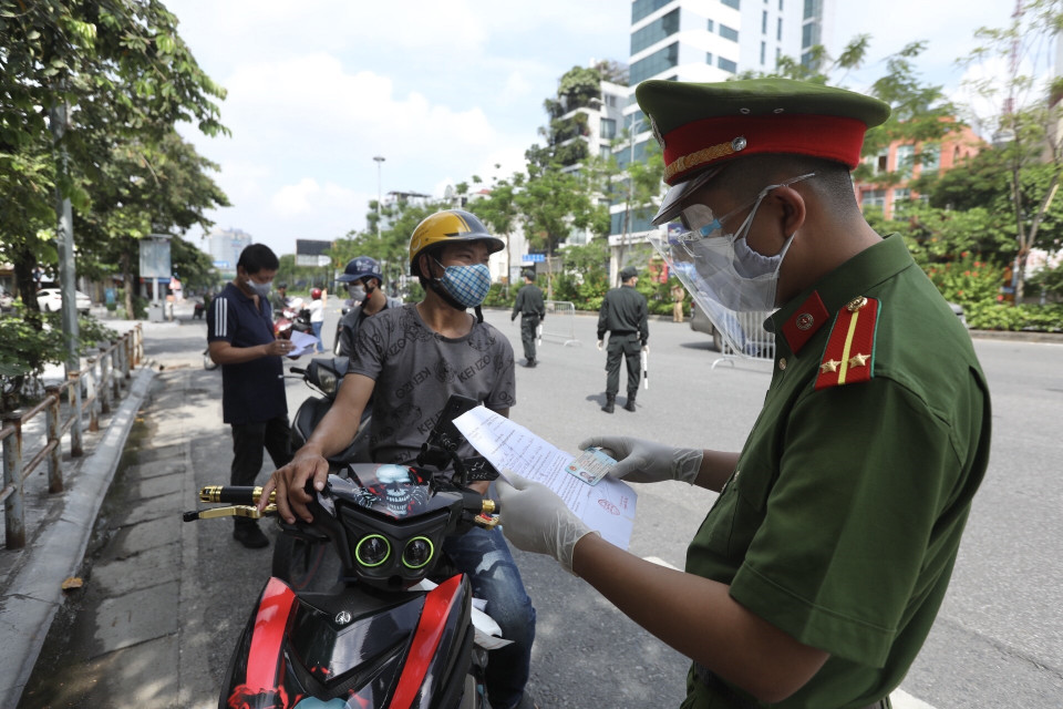 Lực lượng chức năng kiểm tra giấy đi đường, thông tin của người tham gia giao thông tại tổ kiểm soát liên ngành trên địa bàn quận Hai Bà Trưng. (Ảnh: Minh Quyết/TTXVN)