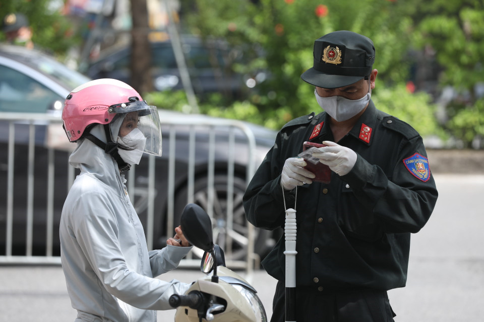 Lực lượng chức năng kiểm tra giấy đi đường, thông tin của người tham gia giao thông tại tổ kiểm soát liên ngành trên địa bàn quận Hai Bà Trưng. (Ảnh: Minh Quyết/TTXVN)