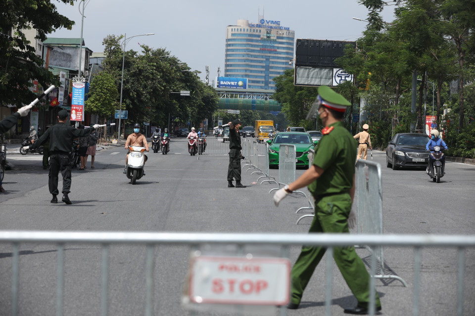 Lực lượng chức năng lập hàng rào phân luồng phương tiện, kiểm soát chặt người và phương tiện khi ra đường. (Ảnh: Minh Quyết/TTXVN)