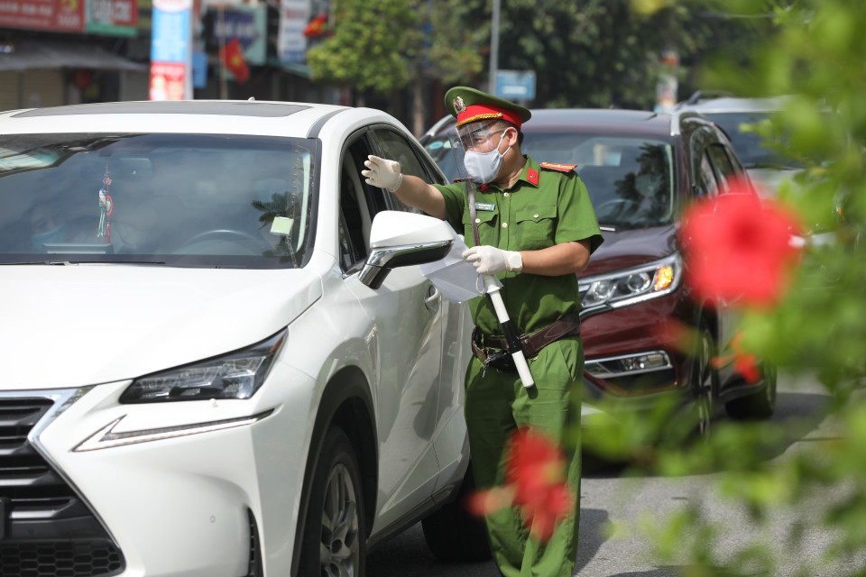 Lực lượng chức năng kiểm tra giấy đi đường, thông tin của người tham gia giao thông tại tổ kiểm soát liên ngành trên địa bàn quận Hai Bà Trưng. (Ảnh: Minh Quyết/TTXVN)