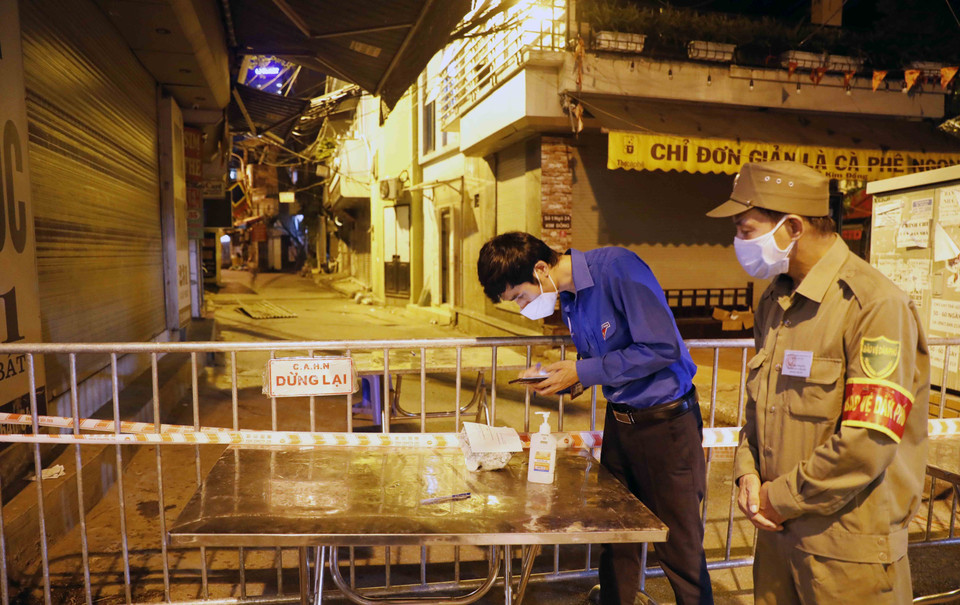 Đoàn viên thanh niên tham gia hỗ trợ chuyển hàng cho người dân tại các khu cách ly trong đêm. (Ảnh: Trần Việt/TTXVN)