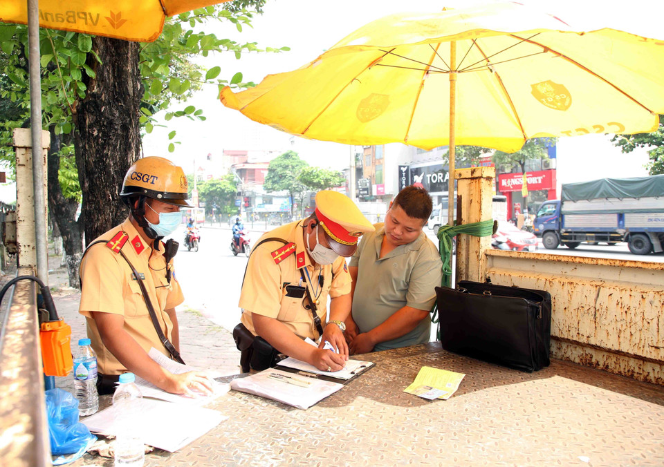 Một chủ xe khách chạy rùa bò vi phạm trật tự An toàn giao thông bị lực lượng cảnh sát giao thông số 14 lập biên bản xử lý. (Ảnh: Phạm Kiên/TTXVN)
