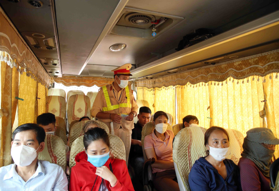 Cán bộ, chiến sỹ Đội cảnh sát giao thông số 14 kiểm tra một trường hợp xe khách đón, trả khách sai quy định. (Ảnh: Phạm Kiên/TTXVN)