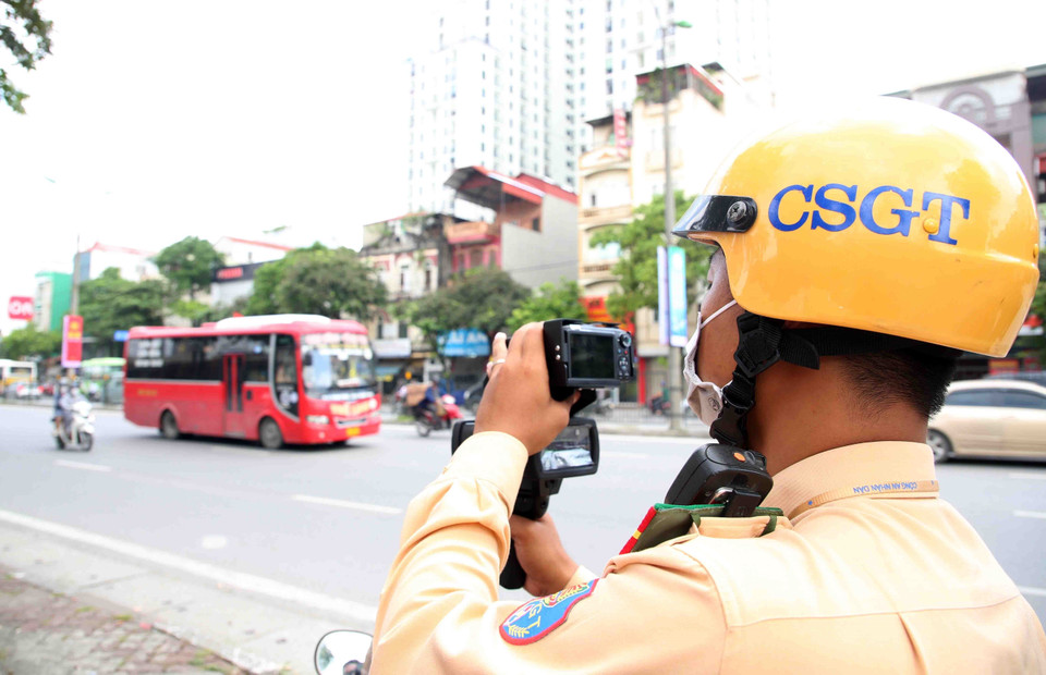 Cán bộ, chiến sỹ Đội cảnh sát giao thông số 14 (Công an thành phố Hà Nội) tiến hành bắn tốc độ với các trường hợp xe khách chạy 'rùa bò' trên đường Giải Phóng. (Ảnh: Phạm Kiên/TTXVN)