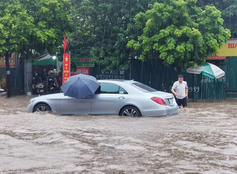 Phương tiện ôtô cũng bị chết máy, không thể đi qua đoạn ngập nặng. (Ảnh: PV/Vietnam+)