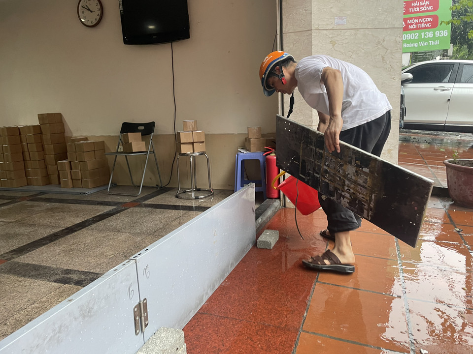 Một người dân đang gia cố chắn mưa ngập. (Ảnh: Minh Hiếu/Vietnam+)