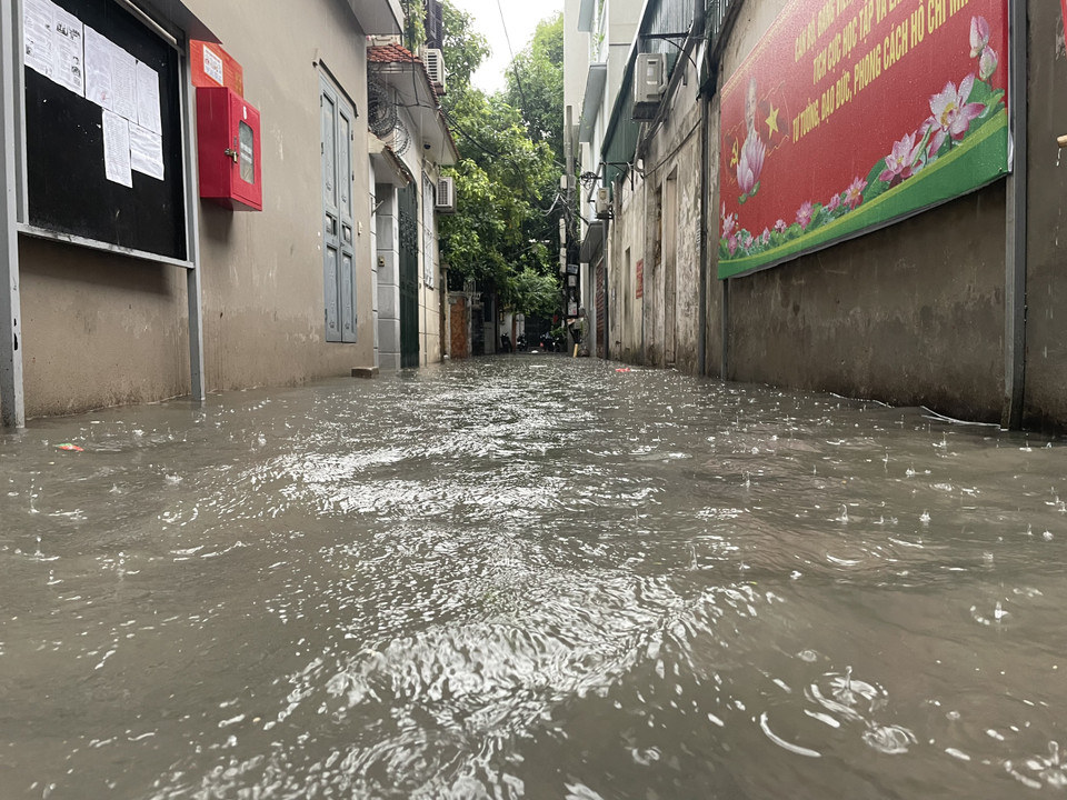 Mưa ngập tràn vào các con ngõ tại Thủ đô. (Ảnh: Minh Hiếu/Vietnam+)