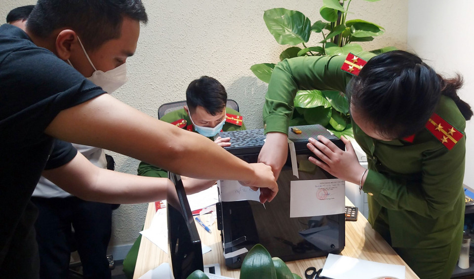 Lực lượng chức năng khám xét và niêm phong, thu giữ tài liệu tại trụ sở FLC. (Ảnh: Phạm Kiên/TTXVN)