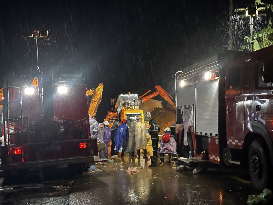 Mặc dù lực lượng chức năng khoảng 100 người, cùng nhiều phương tiện xe cơ giới, máy múc xuyên đêm thực hiện giải toả hiện trường nhưng do lượng đất đá quá lớn nên hiện mới chỉ dọn dẹp được một phần mặt đường để phục vụ công tác cứu hộ. (Ảnh: Nguyễn Dũng/TTXVN) 