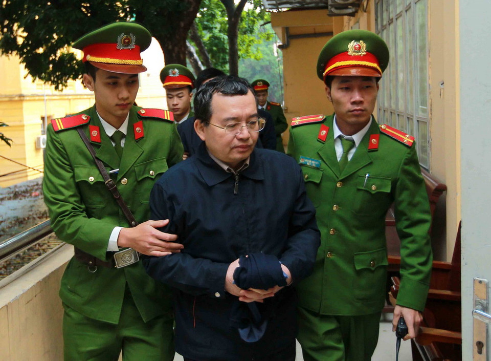 Cảnh sát dẫn giải bị cáo Nguyễn Quốc Khánh vào phòng xét xử. (Ảnh: Doãn Tấn/TTXVN)