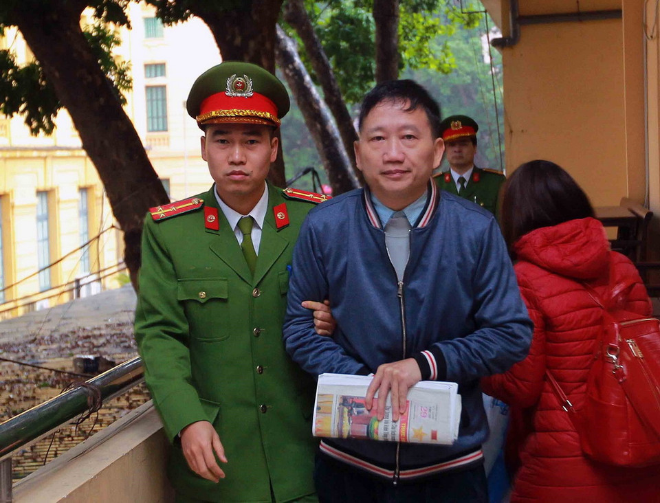 Cảnh sát dẫn giải bị cáo Trịnh Xuân Thanh vào phòng xét xử. (Ảnh: Doãn Tấn/TTXVN)